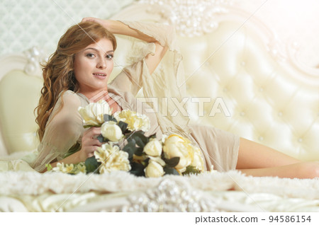 Young beautiful woman waking up on bed Young beautiful woman waking up on bed 94586154