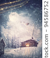Magical holiday scene and Santa Claus sleigh with reindeers flying above the snowy house in the Christmas Eve. Wonderful snowflakes covering the village, and the full moon comes out of the clouds 94586752