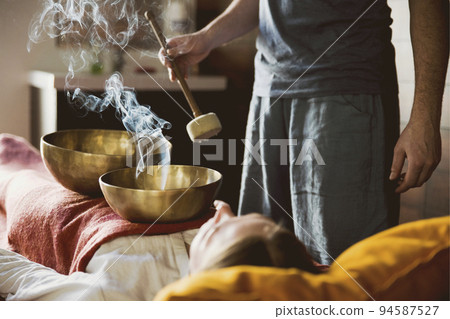 Tibetan singing bowls with smoke in sound therapy in spa center 94587527
