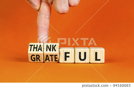 Thankful and grateful symbol. Concept words Thankful and Grateful on wooden cubes. Businessman hand. Beautiful orange table orange background. Business thankful and grateful concept. Copy space. Thankful and grateful symbol. Concept words Thankful and Grateful on wooden cubes. Businessman hand. Beautiful orange table orange background. Business thankful and grateful concept. Copy space. 94588065