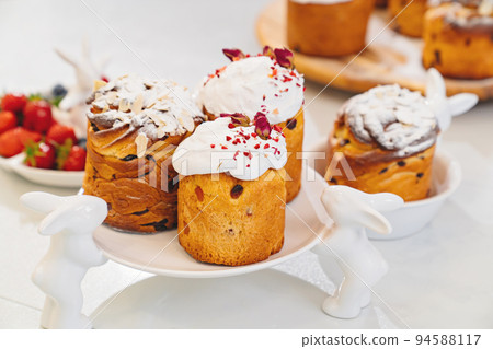 decorated panettones and cruffins on serving plates with rabbits. easter cakes. decorated panettones and cruffins on serving plates with rabbits. easter cakes. 94588117