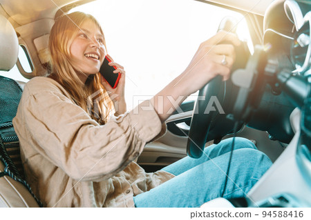 Woman drives dangerously with smartphone in hand Woman drives dangerously with smartphone in hand 94588416