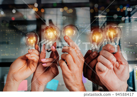 Teamwork and brainstorming concept with businessmen that share an idea with a lamp Teamwork and brainstorming concept with businessmen that share an idea with a lamp 94588417