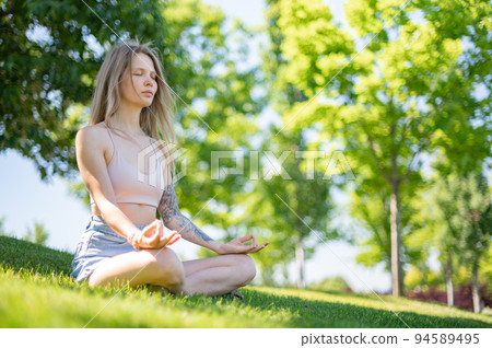 Girl practice yoga meditation outdoor in park Girl practice yoga meditation outdoor in park 94589495