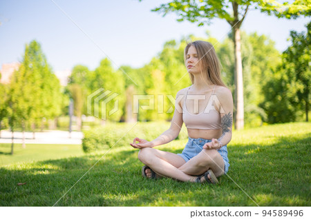 Girl practice yoga meditation outdoor in park Girl practice yoga meditation outdoor in park 94589496