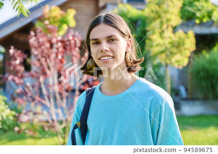 Outdoor portrait of teenage guy with backpack looking at camera Outdoor portrait of teenage guy with backpack looking at camera 94589675