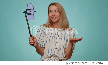 Girl blogger take selfie on mobile phone selfie stick communicate video call online with subscribers 94589676