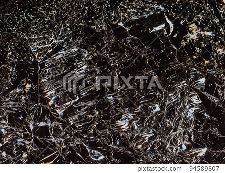 Worn abstract background. Creased texture. Crumpled plastic film. Orange white ripples on gritty dark black illustration overlay. 94589807