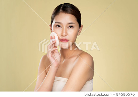 Ardent woman applying her cheek with dry powder while looking at camera. Ardent woman applying her cheek with dry powder while looking at camera. 94590570