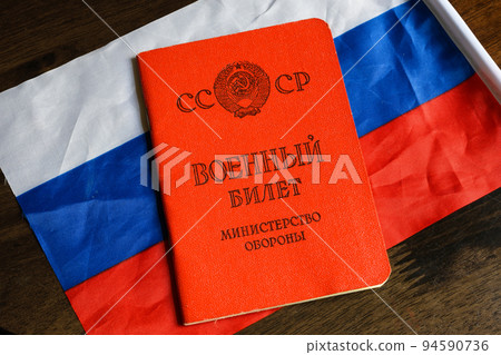 Certificate of Soviet Union serviceman and Russian flag on table Certificate of Soviet Union serviceman and Russian flag on table 94590736