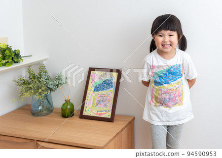 A 4-year-old child who prints a drawing on a T-shirt (illustration, printing, commemoration, memory) 94590953