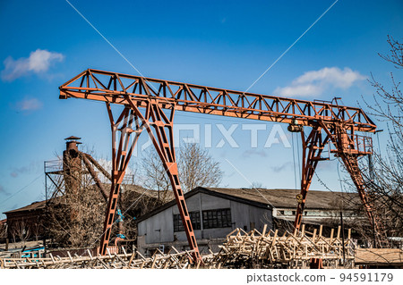 Old rusty gantry crane at abandoned construction site. 94591179