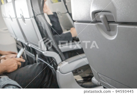 Selective focus on a closed table, a table for food in the cabin, a blurred background of passengers in the background of the interior, the concept of convenient flights and travel 94593445