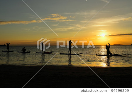 黃昏時分，在祖師海岸的陽光下享受 SUP 瑜伽的年輕人 94596209