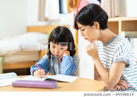 Elementary school girl and mother doing homework 94596614