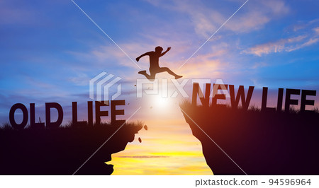 Silhouette man jumping from OLD LIFE to NEW LIFE wording on cliffs with cloud sky and sunrise. Achievement, and Business Concept. 94596964