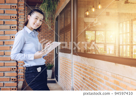 Portrait of young mixed race businesswoman holding her taplet during working. Portrait of young mixed race businesswoman holding her taplet during working. 94597410