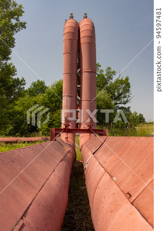 Hot water - steam pipes with bridging in summer nature 94597481