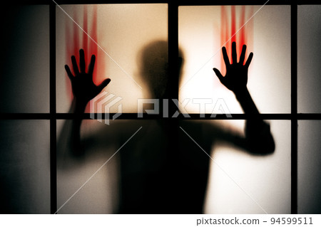 silhouette scared man with red bloody hand stand behind glass door , horror background silhouette scared man with red bloody hand stand behind glass door , horror background 94599511