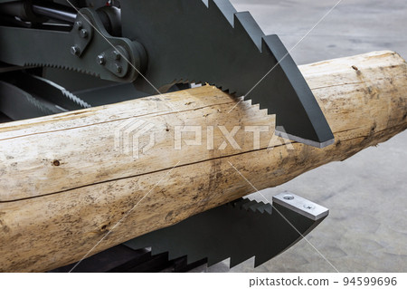 log is clamped by a manipulator arm at a sawmill 94599696
