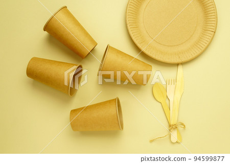 Eco craft paper and wooden cutlery tableware. Paper cups, dishes. Recycling or eco-friendly concept. 94599877