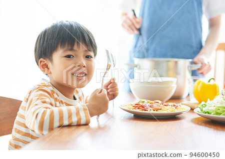 Mother and boy preparing meals 94600450