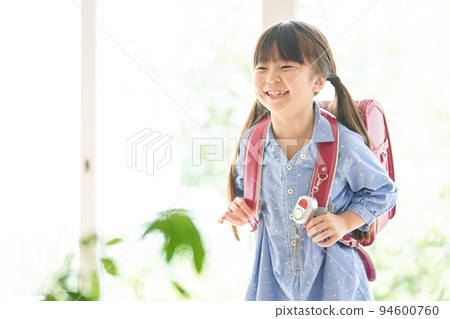 Girl carrying a school bag at home 94600760