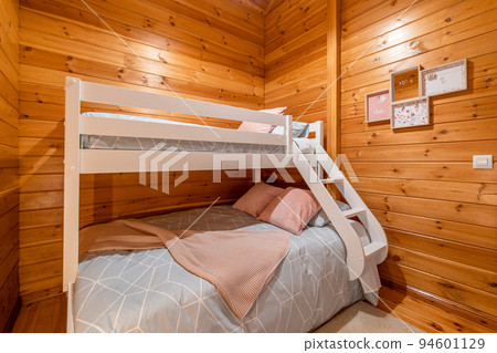Children bedroom with bunk bed and wooden walls. Cozy and comfortable cottage interior. Children bedroom with bunk bed and wooden walls. Cozy and comfortable cottage interior. 94601129
