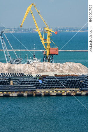 industrial seaport infrastructure, sea, cranes and minerals, metal and bundles of wire, the concept of marine cargo transportation 94601795
