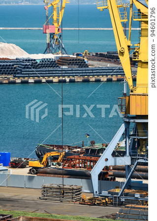 industrial seaport infrastructure, sea, cranes and minerals, metal and bundles of wire, the concept of marine cargo transportation 94601796