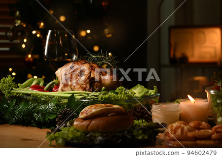 Roasted turkey on Thanksgiving table or Christmas dinner by candlelight in a decorated room with a Christmas tree Roasted turkey on Thanksgiving table or Christmas dinner by candlelight in a decorated room with a Christmas tree 94602479