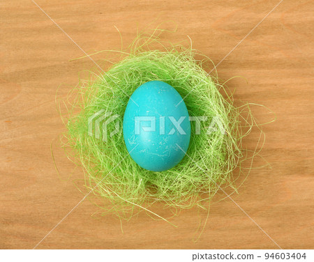 easter egg in a nest of grass on a wooden background, holiday still life and decorations easter egg in a nest of grass on a wooden background, holiday still life and decorations 94603404
