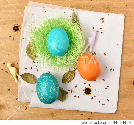 easter eggs in a nest of grass on a wooden background, holiday still life and decorations easter eggs in a nest of grass on a wooden background, holiday still life and decorations 94603409