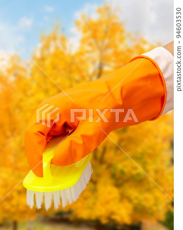 Woman's hand in protective glove with brush. Woman's hand in protective glove with brush. 94603530