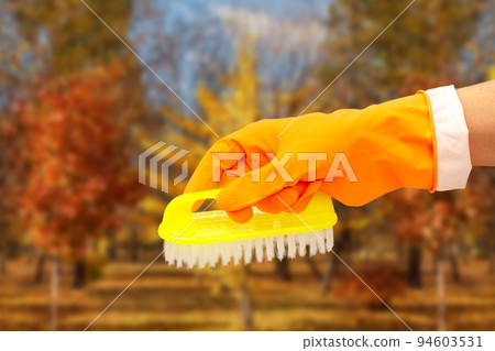 Woman's hand in protective glove with brush. Woman's hand in protective glove with brush. 94603531