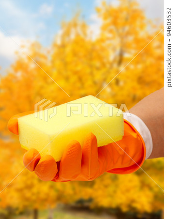 Woman's hand in protective glove with sponge. 94603532