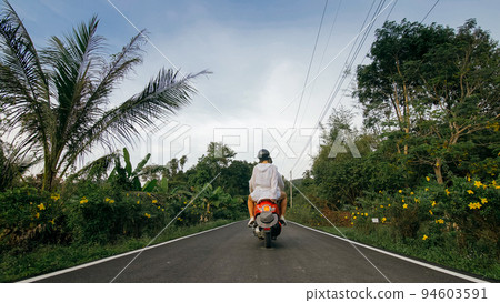 Love couple on red motorbike in white clothes to go on forest road trail trip. Two caucasian tourist woman man drive on scooter. Motorcycle rent. Love couple on red motorbike in white clothes to go on forest road trail trip. Two caucasian tourist woman man drive on scooter. Motorcycle rent. 94603591