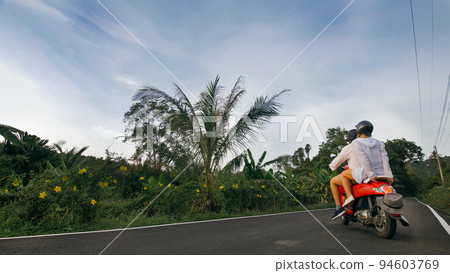 Love couple on red motorbike in white clothes to go on forest road trail trip. Two caucasian tourist woman man drive on scooter. Motorcycle rent. Love couple on red motorbike in white clothes to go on forest road trail trip. Two caucasian tourist woman man drive on scooter. Motorcycle rent. 94603769