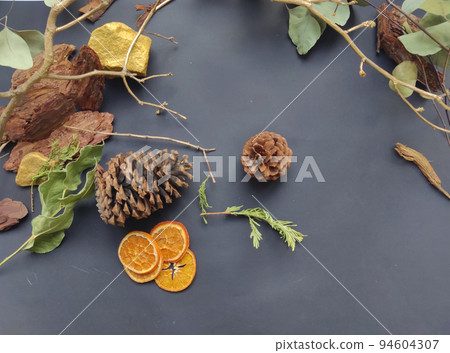 Christmas flat lay background made of natural winter things on dark blackboard. Fir tree branch, natural forest acorn, plants, dry slices of oranges. Christmas flat lay background made of natural winter things on dark blackboard. Fir tree branch, natural forest acorn, plants, dry slices of oranges. 94604307