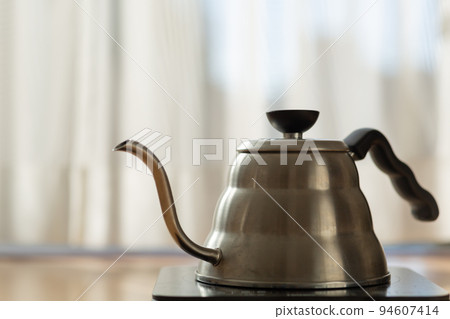 [Japan] A silver kettle placed in front of the curtain by the window where the morning sun shines 94607414