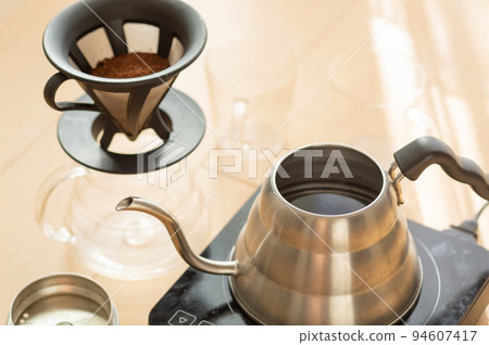 [Japan] A coffee dripper and two glasses placed around a silver kettle that boils water 94607417