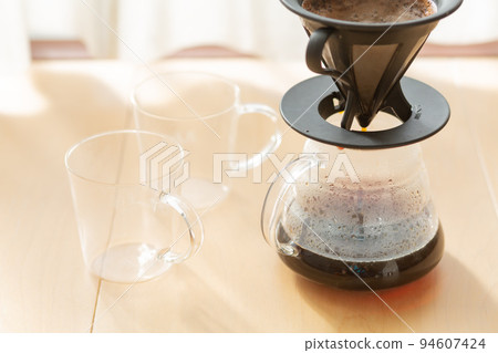 [日本] 咖啡服務員、玻璃杯和滴漏式咖啡放置在早晨陽光照耀的窗戶旁的地板上 94607424