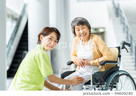 Senior woman in wheelchair and middle care worker 94609280
