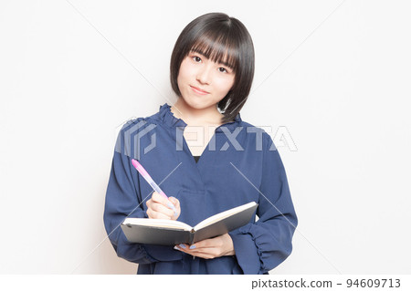 Young woman writing notes in a notebook 94609713