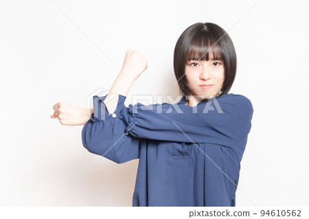 在白色背景前伸展的年輕女子 在白色背景前伸展的年輕女子 94610562