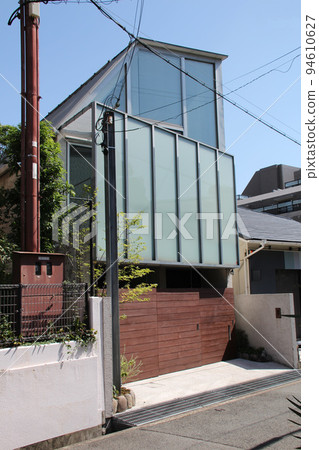 A stylish and fashionable mansion with a beautiful vertical glass screen and horizontal sliding doors that shine against the blue sky A stylish and fashionable mansion with a beautiful vertical glass screen and horizontal sliding doors that shine against the blue sky 94610627