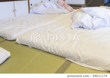 Japanese-style inn room with tatami mats and futons 94611174