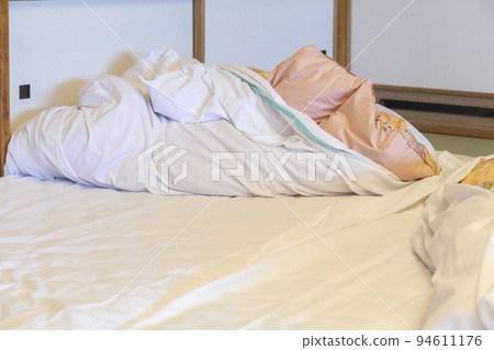 Japanese-style inn room with tatami mats and futons 94611176