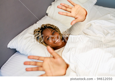latin hispanic woman stretch after sleeping in the morning at home latin hispanic woman stretch after sleeping in the morning at home 94612050