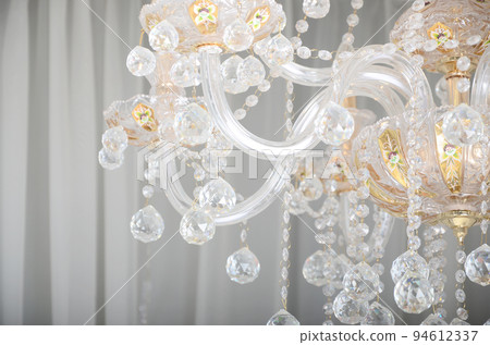 Close-up photo of the scenery on the old chandelier. Glass figures shine and reflect light with their faces Close-up photo of the scenery on the old chandelier. Glass figures shine and reflect light with their faces 94612337